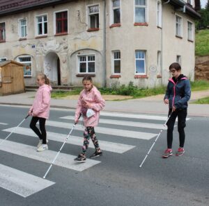 Niewidome dzieci uczą się przechodzić przez przejście dla pieszych